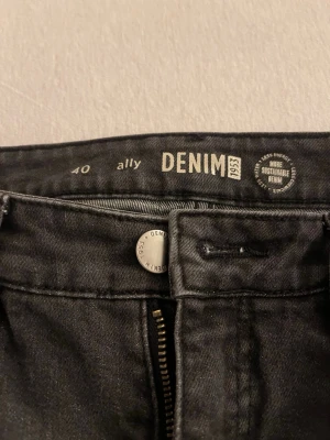 Svarta jeans från Denim 1953 - Snygga svarta jeans från Denim 1953 med klassisk femficksmodell och dragkedjegylf. Jeansen har raka ben och är tillverkade i ett hållbart denimtyg. Perfekta för en stilren och avslappnad look.