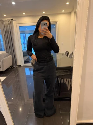 Svarta wide Jordan mjukisbyxor - Säljer ett par svarta mjukisbyxor med bred resår i midjan och vida ben. Byxorna har en avslappnad passform och är perfekta för en chill och bekväm stil. Materialet känns mjukt och skönt mot huden.