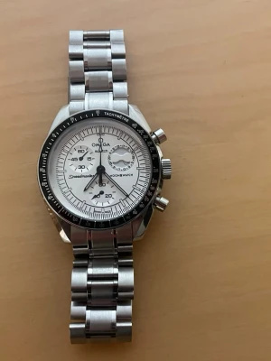 Omega x Moonswatch Snoopy modification - Säljer en Moonswatch Snoopy i eget modifierat utförande. Klockan är baserad och inspirerad av Omega x Swatch Moonswatch snoopy och har blivit modifierad för ett mer exklusivt utseende.   Klockan är i väldigt bra skick förutom några få dammpartiklar i glaset som endast syns om man kollar noga.  Snälla kontakta mig ifall ni har några frågor!