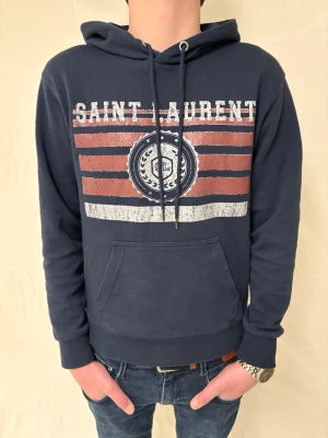 SAINT LAURENT HOODIE - Marinblå Saint Laurent hoodie i S. Nypris 8000kr vårt pris 1299kr! Om ni har några frågor kontakta oss!