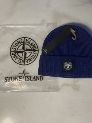 Stoone Island Mössa - Säljer en helt ny vit mössa i perfekt skick. Aldrig använd. Stilren och enkel modell som passar till vardags – unisex.  📌 Detaljer: • Skick: Helt ny / oanvänd • Storlek: One size • Färg: Blå • Passform: Bekväm  💰 Pris: kan diskuteras vid snabb affär  📦 Frakt: skickas direkt efter köp (köparen står för frakt)