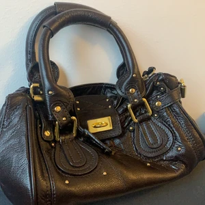 Chloé vintage handväska  - Köpt på secondhand, därmed troligtvis ej äkta. Fin vintage handväska med guldiga detaljer. Lite sliten som man kan se i tredje bilden, annars en jätte fin väska! Lås och nyckeln medföljer
