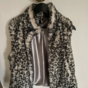 SNYGG VÄST  - Väst i pälsimitation i Stl 38. Snygg att ha över en skinnjacka! Fint skick! 
