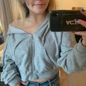 Grå luvtröja - Grå zip-up hoodie. Modellen är lite croppad och ganska boxig vilket ger en väldigt cool fit!⚡️ (säljer även jeansen i en annan annons!)