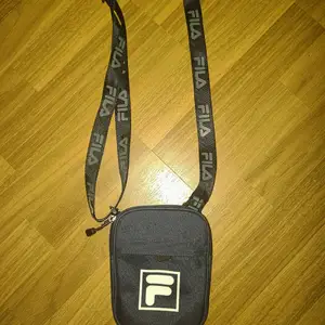 En liten mörkblå fila väska med plats för plånbok och ytterfack.