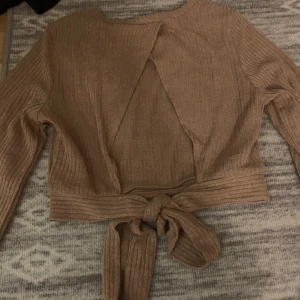 Tröja med öppen rygg - Beige/ljusrosa tröja med öppen rygg. Köparen står för frakt