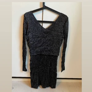 Fin glittrig klänning  - Klänning i glittrigt material, urringad rygg. Köparen står för frakt. 