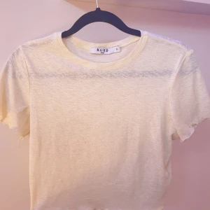 Ljus gul crop topp - Ljus gul crop topp från nakd som är som ny. Den har hyfsat genomskinligt material och är kort i modellen. Den är i storlek xs men sitter väldigt bekvämt pga materialet❤