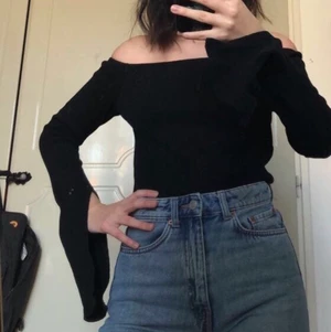Tröja - Svart långärmad offshouldertröja med en liten slits längst ner på ärmen. Väldigt snygg och lätt att klä upp! Aldrig använd endast testad.