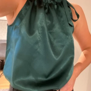 Halterneck topp - En grön halterneck topp i silkesmaterial. Som ny då den endast är använd några fåtal gånger. 