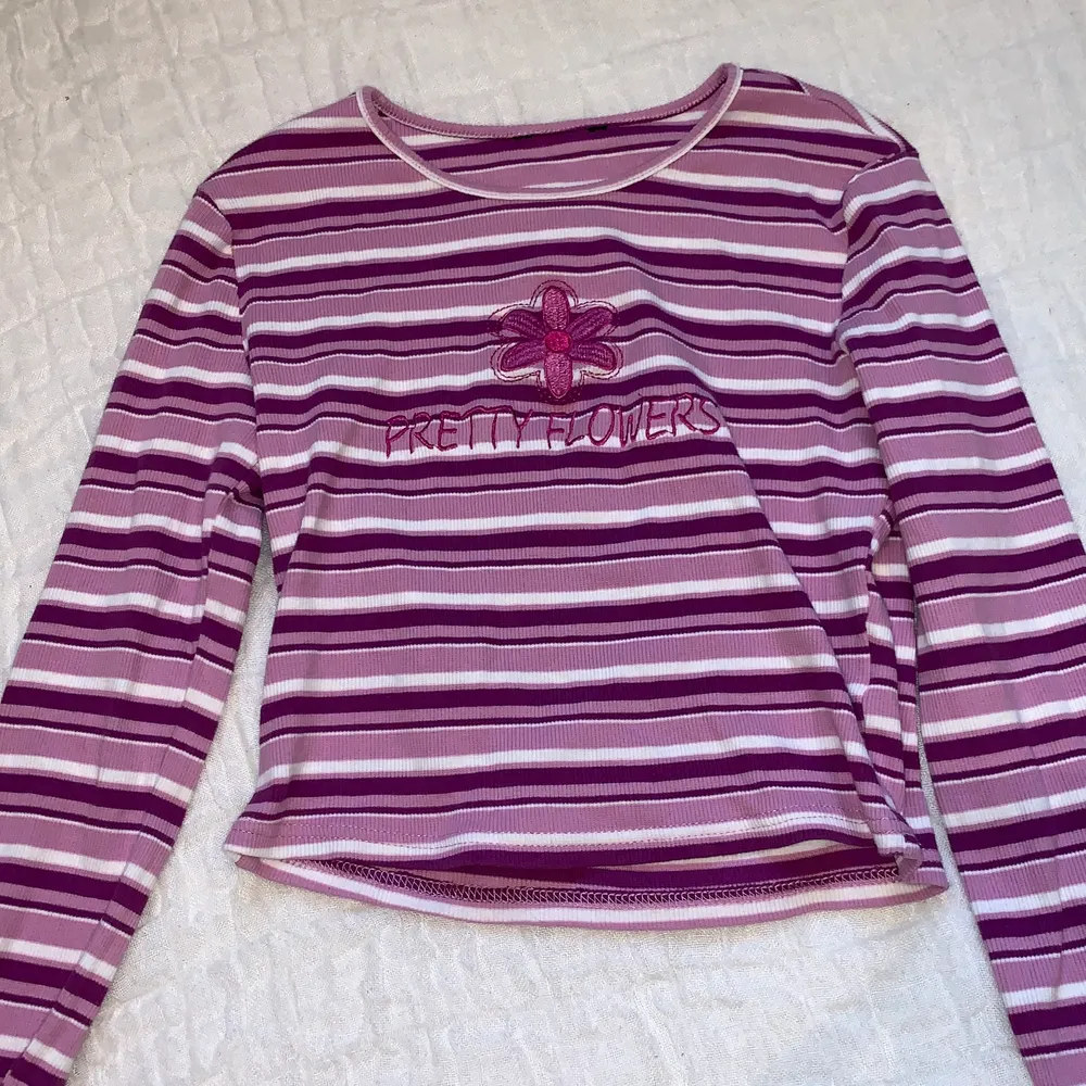 Long-sleeved, striped, purple and pink top with cute lettering and flower patchwork // Good condition // Buyer pays for shipping (even though it says frees shipping in the post) . Toppar.