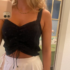 Svart topp - Jättesnygg svart topp i nyskick. Jag brukar ha storlek S i plagg men denna är M. Går att styra hur åtdragen den ska vara i mitten. Köpare står för frakten på 24kr.