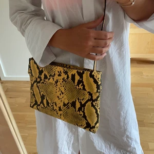 Väska / Clutch - Väska / clutch i gult ormskinn från Parfois. Helt ny!💕 Använd max 2 ggr. Säljer pågrund av att jag har för många väskor… Nypris: ca 350 kr  