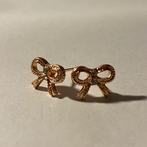 Örhängen - Silverörhängen i form av en rosett med kristaller och gulddetaljer.