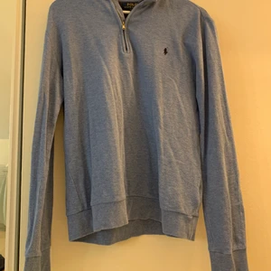 Ralph lauren half zip - Blå ralp lauren half zip som tyvär är förliten.