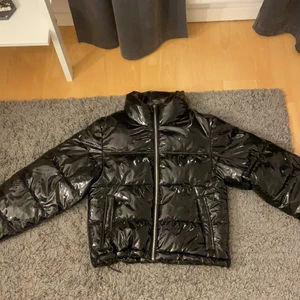 Svart glansig Vinterjacka - Varm och svinsnygg vinterjacka! Inte särskilt använd! Köpt från Ginatricot! Skulle säga att den passar S också