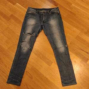 Vintage low rise jeans. Hål i jeansen är DIY.