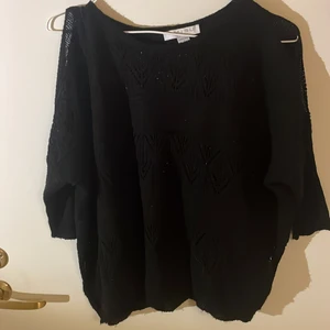 Stickad skön svart tröja  - Svart stickad tröja med hål vid axlarna. 