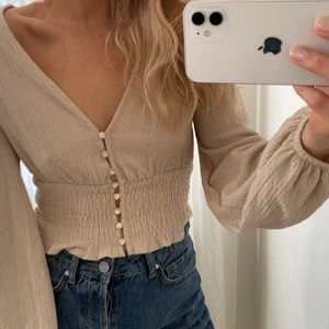Topp från Monki  - Beige topp med ballongärm från Monki i strl S. Inköpt sommaren 2020 och har använts 2 gånger. Säljes pga flytt och har tyvärr inte plats.