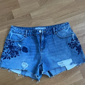 AMISU SHORTS - Ett par jeans shorts med fina tryck på både fram- och backsida. Använt 2 gånger. Storlek: 40. Anledning till varför jag säljer de är för att de är för stora. Om ni har flera frågor är det bara att höra av er :) 