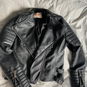 Skinnjacka från chiquelle storlek 40  - Jätte fin skinnjacka från chiquelle med fina detaljer på axlar, armar och sidan. Själv ”fodret” inne i jackan har spruckit men det är inget som syns från utsidan och går säkert jätte lätt att sy ihop. Skinnet ser nästan glittrigt ut på bilden men det är helsvart egentligen. 💕 köparen står för frakten och jag ansvarar ej om paketet skulle försvinna påvägen 😊