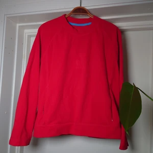 Fleecetröja - Röd fleecetröja med fickor, den har en logga mitt på bröstet som var svår att fånga på bild, skymtar på sista bilden🍒
