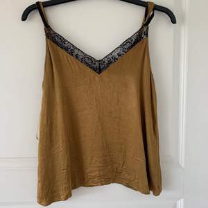 Ett linne från Zara, guld/brunt med spets detalj. Strl S, 80kr, frakt tillkommer!