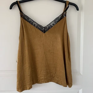 Top - Ett linne från Zara, guld/brunt med spets detalj. Strl S, 80kr, frakt tillkommer!