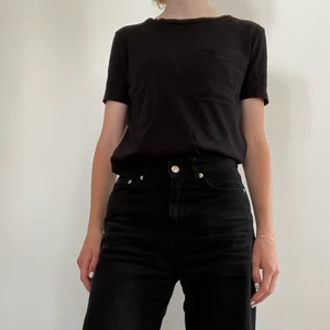 Svart t-shirt från Zara - En fin t-shirt med ficka på bröstet från Zara. Sparsamt använd. Går att styla med många olika accessoarer och passar således till många olika outfits. Tveka inte att kontakta mig vid frågor!