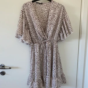 Klänning med mönster och volanger   - Storlek M, mönstret är brunt 