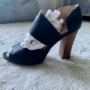 Klackar från Bronx/ äkta kläder/ stl 39/ - Svarta läderklackar i storlek 39 från Bronx. Normala i storleken. Använda 2 gånger. Stabila med rätt bred klack, 10 cm. Fin klack i trä. Säljes då de är för små för mig. Nypris 1 400 kr. Skriv gärna vid frågor :)