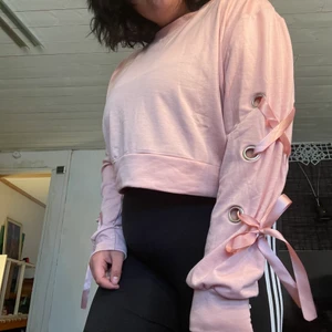 Rosa långärmad croptop korsettdetalj  - Rosa långärmad croptop med snördetaljer på ärmarna. (Slarvigt knutet på bilderna men går att göra om såklart)   Köpt från shein i dec 2020. Använd 1 gång så är i nyskick. Storlek 1XL men passar även L. 💌 Frakt är baserad på frimärken. Önskas postnords blå påsar/kartonger löser vi givetvis det. 