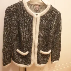 Gråmelerad kofta med vita kanter, väldigt Chanel. Mix av bla ull, angora och mohair. Storlek 36 från H&M, passar även storlek 38. Som ny. 