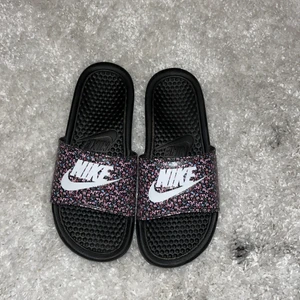 Nike blommiga slides Strl 38 - Blommiga slides från Nike i storlek 38. Använd ett fåtal gånger. Sköna att använda inomhus. Nypris 359kr, slutsålda i Strl 38 online. 