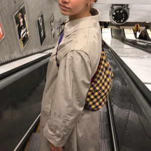 Beige kappa - one Size  - Beige burberry liknande kappa, köpt second hand. Innerficka på höger sida, 65% polyester och 35% bomull. Inga defekter förutom en svag fläk på baksidan, se sista bilden. 