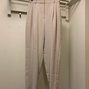 Krämvita kostymbyxor  - Säljer dessa fina kostymbyxor i strl 34 från h&m. Finns några tecken på användning men kan nog fixas ganska lätt. Tror de ska vara croppade men är ganska långa på mig som är 159 cm. 