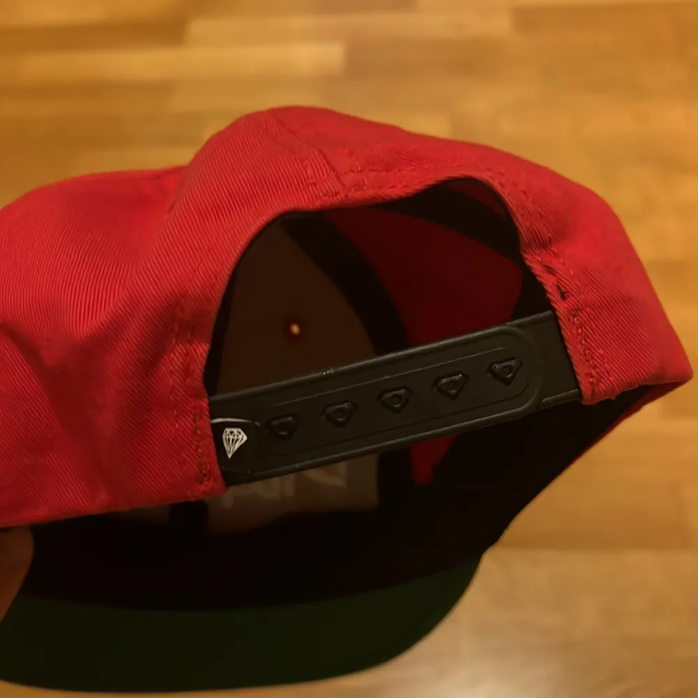 En Röd/Svart/Grön snapback från Diamon supply Co. Övrigt.