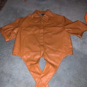 Skinntröja, kortärmad - Skinntröja med knappar, går att knyta längst ner. Fin, knappt använd 