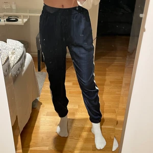 Silkesbyxor från Zara - Mörkblå silkesbyxor med vit rand längs benen från Zara. Storlek xs. Går till anklarna på mig som är 169 cm. Använda ett fåtal gånger! 