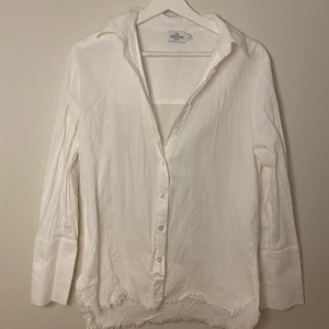 Skjorta från NAKD  - Vit skjorta från NAKD med bred ärm och fransar nertill, Stl.34 