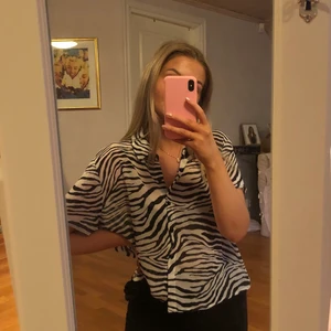 Cool blus från PrincessPolly - Fantastiskt cool och snygg blus/skjorta från PrincessPolly. Aldrig använd. Passar perfekt på en person som vanligtvis har XS, S eller M beroende på hur man vill att passformen ska vara. Jag bär vanligtvis S vilket ger looken på bilderna. Testar att sälja för att den inte riktigt kommer till användning. Hör gärna av dig om du önskar fler bilder. Köparen står för fraktkostnaden.