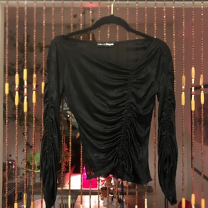 Svart topp med dragsnören  - Svart topp med snörning fram och på båda ärmarna, fin passform som går att ändra med banden 