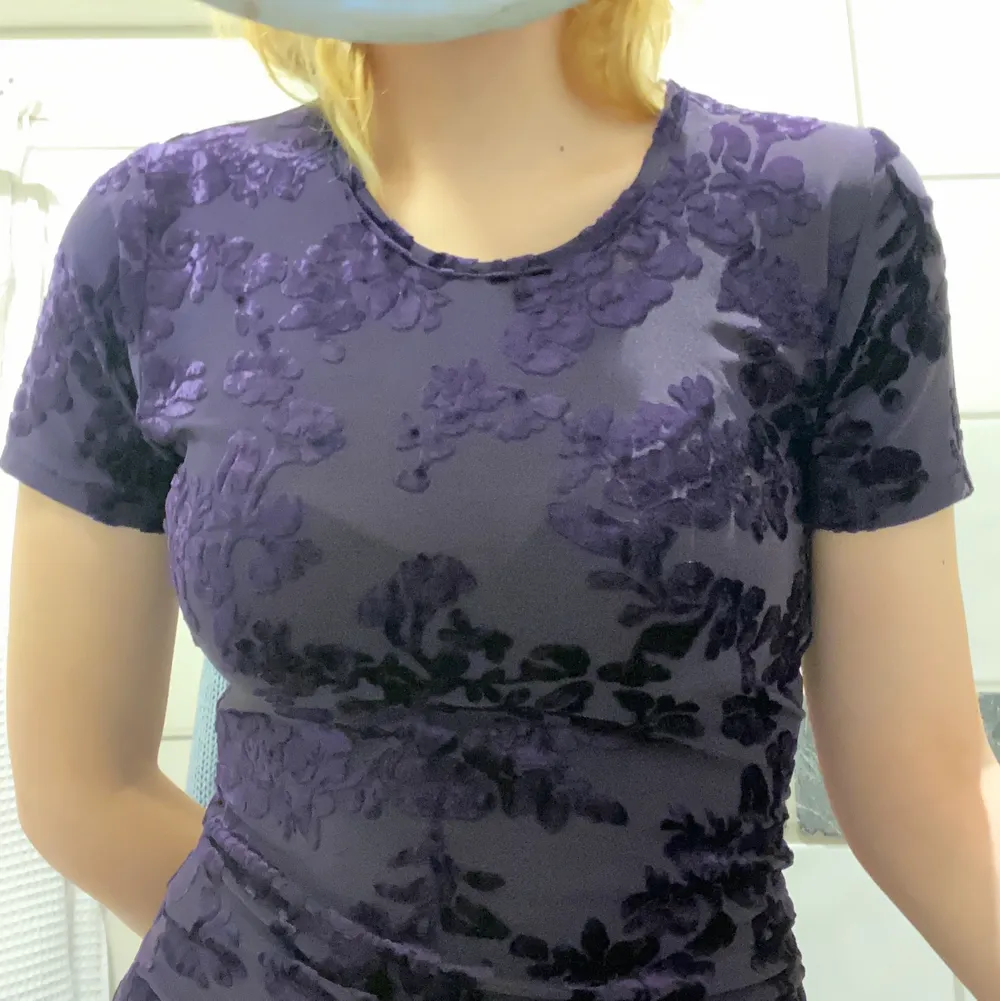 Fin lila T-shirt i ett stretchig mesh material med blommiga detaljer i sammet. Köpt på humana, i fint skick.. T-shirts.