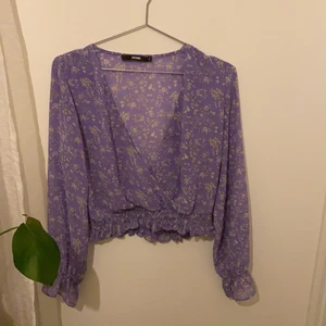 Bakbok blus - Croppad lila-blommig blus. Jätte söt på. Knappt använd i strl S.