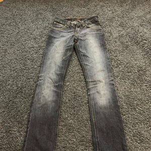 Lågmidjade jeans - Säljer ett par lågmidjade jeans med märket nudie jeans säljer pågrund av inte är riktigt min stil. Tror inte dem finns att köpa längre (men märket är dyrt och kostar över 1000kr). Det är min mammas gamla jeans dem är använda men inget tecken på användning! Innerbens måttet är 82cm och midjemåttet är 68cm. Kontakta privat för fler bilder 