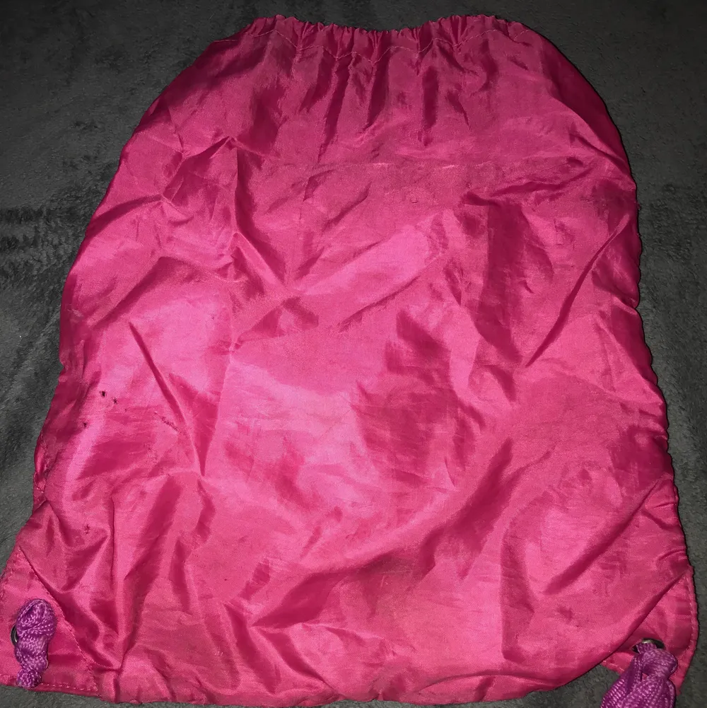 En snygg rosa och lila jympa väska med en ficka. Matrialet är inte så plastigt som det ser ut på bilderna. Väldigt fint skick förutom några hål på baksidan, men dem syns knappt. Kontakta mig för fler bilder. Priset kan diskuteras! ❤️. Väskor.
