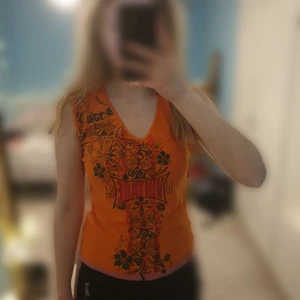 Orange vintagelinne - Ett oranget vintage-linne från ICHI. Storlek L men passar på S och M. Bra skick. Material: polyester/elastin. Skriv vid intresse!