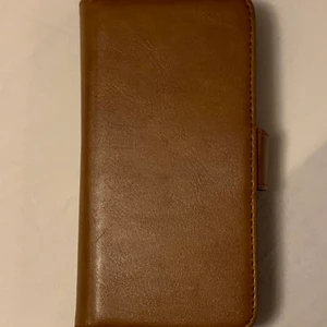 Plånboksskal från Holdit - Säljer ett brunt plånboksskal från Holdit med plats för 6 st betalkort.  Passar till 6 / 6S, 7, 8 och SE.  Nyskick. 120kr. Köparen står för frakten:)