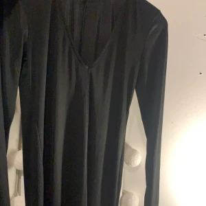 Svart långärmad klänning  - Svart långärmad klänning st S stor i storleken,knälång 