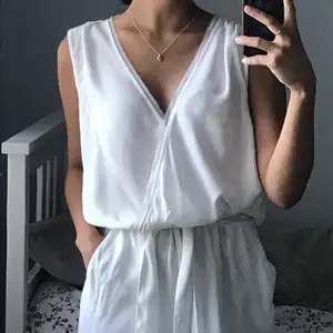 En flowy vit jumpsuit med öppen rygg. Detta är en helt  ny oanvänd jumpsuit köpt av min mamma. Den är lite see-through vilket hon inte gillade.